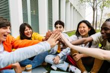 High schoolers putting their hands together