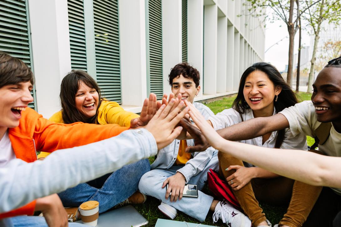 High schoolers putting their hands together